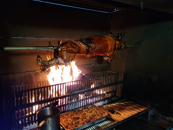 Cochon de lait a la broche avec son jus de cuisson et une garniture